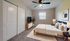 Bright and inviting bedroom with cozy carpet, modern ceiling fan, elegant decor, and ample storage space.
