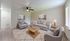 Inviting living room with elegant gray sofas, chic coffee table, and serene wall art, illuminated by natural light.
