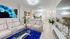 Elegant living area with plush cream recliners, vibrant blue accents, and modern decor, perfect for relaxation and entertaining.