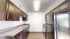 Sleek modern kitchen with elegant dark wood cabinets, granite countertops, and stainless steel appliances.