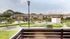 Charming apartment view showcasing a beautifully landscaped courtyard with lush greenery, a mini-golf area, and modern play structures, perfect for outdoor relaxation.
