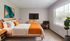 Modern bedroom with cozy double bed, vibrant decor, large window with natural light, and stylish furnishings.