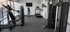 Modern fitness center featuring state-of-the-art equipment, including treadmills, stationary bikes, and multi-station gym machine, in a bright and airy space with floor-to-ceiling windows.