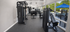 Modern fitness center featuring state-of-the-art exercise machines, bright interior, and a view of the outdoor pool area.