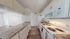Modern kitchen with sleek countertops, white cabinetry, and contemporary appliances exuding elegance and functionality.
