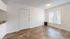 Inviting living area with sleek laminate flooring, natural light from a large window, and modern neutral tones.