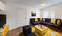 Bright and modern living room showcasing a stylish navy couch with vibrant yellow accents, a sleek coffee table, and contemporary decor.