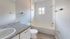 Bright and modern bathroom with sleek granite countertops, contemporary fixtures, and a classic bathtub.