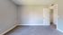 Bright, freshly painted room with plush carpet and elegant white doors, offering a blank canvas for personalization.
