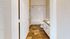 Inviting bathroom with elegant granite countertop, stylish wood flooring, and classic white bathtub.