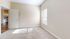 Bright, airy room with plush carpeting and ample natural light, ideal for versatile living space.