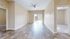 Bright and spacious living room with elegant wood flooring, neutral wall colors, and large patio doors opening to a serene view.