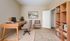 Inviting home office with elegant wooden desk, comfortable chair, and stylish bookshelf for a productive work environment.