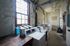 Resident laundry room at Old Heidelberg Apartments with multiple washers and dryers, large windows, and ample workspace.