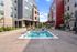 Apartments In Chesterfield, MO - Resort-Style Jacuzzi Surrounded By A Sundeck, Lounge Seating, String Lighting, And Maintained Landscape.