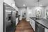 Modern kitchen with stylish stainless steel appliances, elegant dark countertops, and a spacious pantry, perfect for culinary enthusiasts.