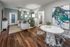 Chic open-concept living room and dining area featuring modern decor, elegant hardwood floors, and vibrant artwork.