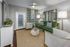Elegant living room with a plush green sofa, stylish armchairs, and modern decor, offering a cozy yet sophisticated ambiance.