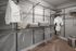 Spacious walk-in closet with organized shelving, clothing, and storage bins; elegant and functional design.