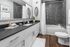 Elegant bathroom with modern design featuring a sleek vanity, stylish black countertop, and chic subway tile walls.