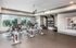 Modern fitness room with sleek exercise bikes, large windows, and well-organized gym equipment.