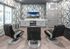 Modern entertainment room with sleek black chairs, geometric wallpaper, and a mounted flat-screen TV.