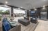 Modern outdoor lounge featuring cozy wicker seating, a sleek stainless steel fridge, and a premium wall-mounted TV under recessed lighting.