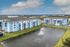 Vibrant blue apartment complex with modern design, overlooking a serene pond with a stunning fountain feature.