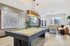 Modern entertainment room with a sleek billiards table, stylish leather seating, and elegant decor, perfect for social gatherings.
