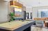 Chic recreation room with modern pool table, stylish brick wall, plush seating, and natural light perfect for relaxation and entertainment.