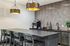Modern kitchen design featuring elegant pendant lighting, a sleek countertop with seating for four, and a stylish backsplash.