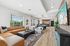 Chic open-concept apartment showcasing a stylish living area with a tan sectional sofa, modern kitchen, and inviting recreation space with pool table.