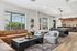Bright and inviting living space featuring a cozy seating area with modern furniture, stylish pool table, and large windows offering scenic views.
