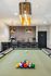 Modern recreation area featuring a pool table with vibrant balls, elegant lighting, and a stylish bar for ultimate relaxation.