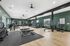 Spacious and modern fitness center with state-of-the-art gym equipment, featuring treadmills, weight machines, and large mirrors on a polished wood floor.