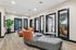 Modern office lounge with chic seating, stylish wood flooring, and elegant glass-paneled doors, featuring lush indoor plant decor.