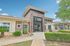 Charming brick building of The Foundry with modern design, lush landscaping, and inviting entrance under a bright blue sky.
