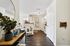 Chic apartment entryway with elegant decor, leading to a modern kitchen and cozy open living space.