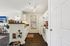 Bright and inviting kitchen featuring sleek white cabinetry, modern appliances, and stylish decor with a cozy pet nook.