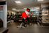 Modern fitness center featuring state-of-the-art equipment and a unique character lifting weights, creating a fun workout experience.