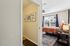 Inviting bedroom with large window, vibrant d&eacute;cor, and stylish artwork, providing a warm and cozy atmosphere.