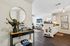 Chic and modern living area with open layout, sleek kitchen design, elegant decor, and inviting hardwood floors.