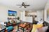 Inviting open-concept living room with cozy seating, vibrant decor, and modern kitchen, perfect for relaxed living and entertaining.