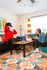 Bright and cozy living room featuring playful decor and a vibrant carpet, where two people enjoy a fun game on a modern coffee table.