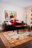 Vibrant living room featuring a colorful abstract painting, stylish mid-century lamps, and a plush area rug, creating a cozy and inviting atmosphere.