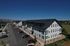 Modern apartment building with elegant architecture, ample parking, and a scenic mountain backdrop.