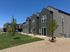 Row of stylish modern townhouses with sleek gray design, large windows, and landscaped surroundings.