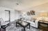 Inviting living room with a stylish white sofa, decorative pillows, modern art, and elegant lighting.