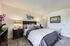 Luxurious bedroom featuring a plush bed with elegant bedding, matching nightstands, chic wall décor, and ambient lighting.