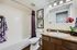 Bright and modern bathroom with stylish decor, featuring a vanity, artwork, and vibrant accents.